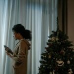 navidad ansiedad, pino de navidad y persona con móvil